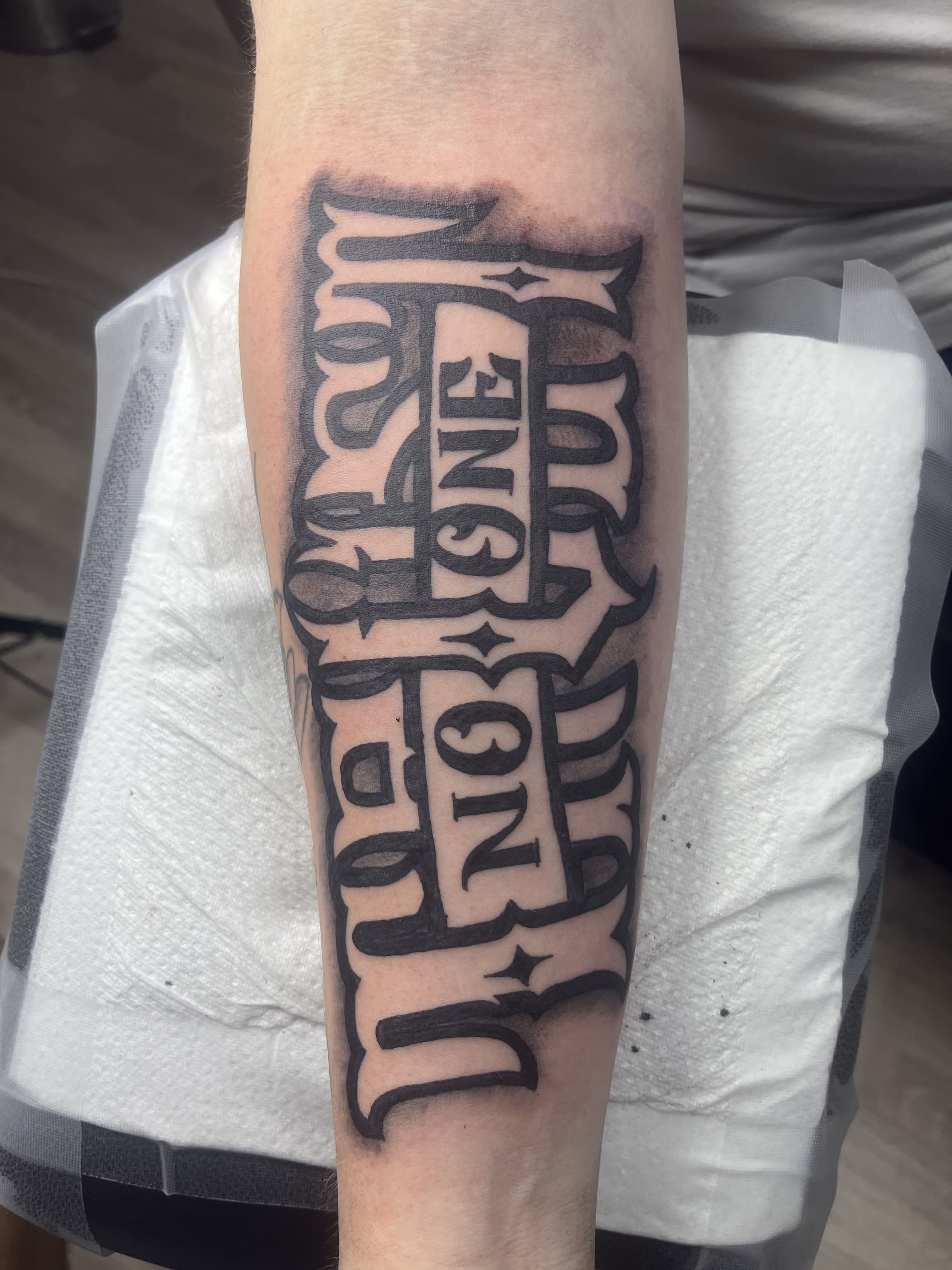 Unterarm-Tattoo mit coolem Schriftzug im Tnt-Tattoo Studio in Zentrum von Herford.