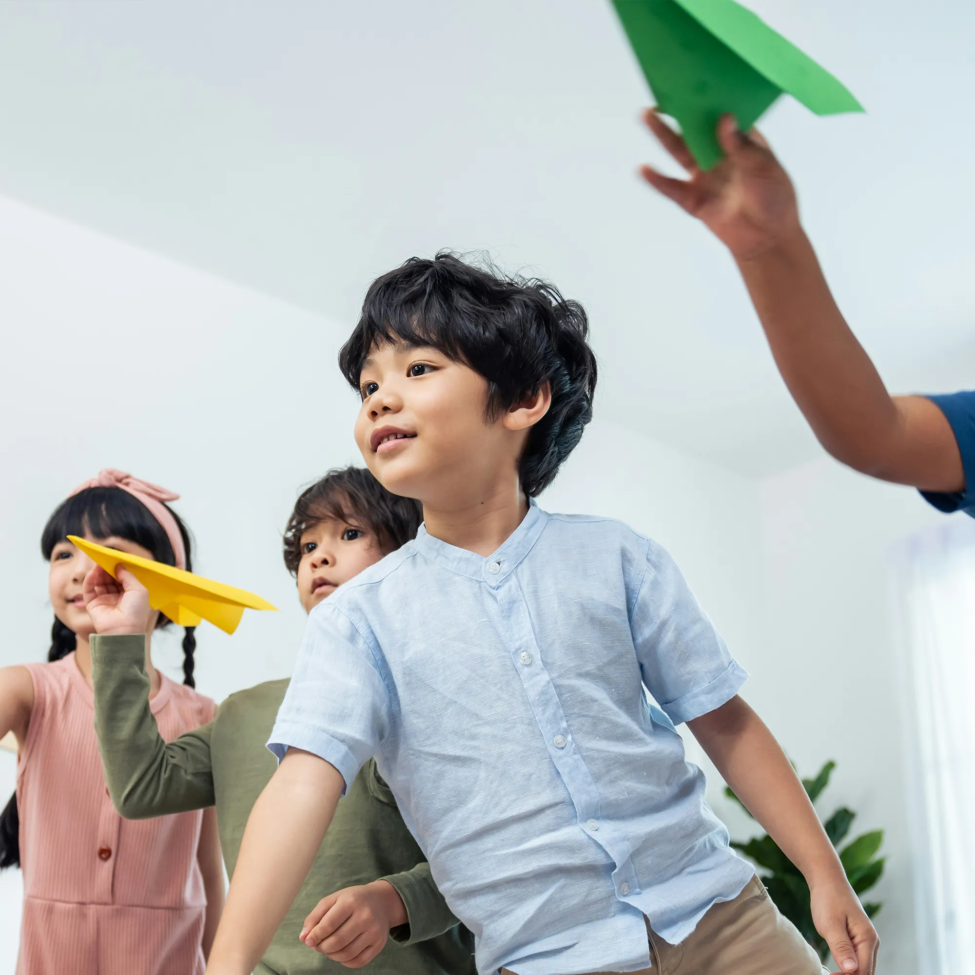 Barn som kastar pappersflygplan.