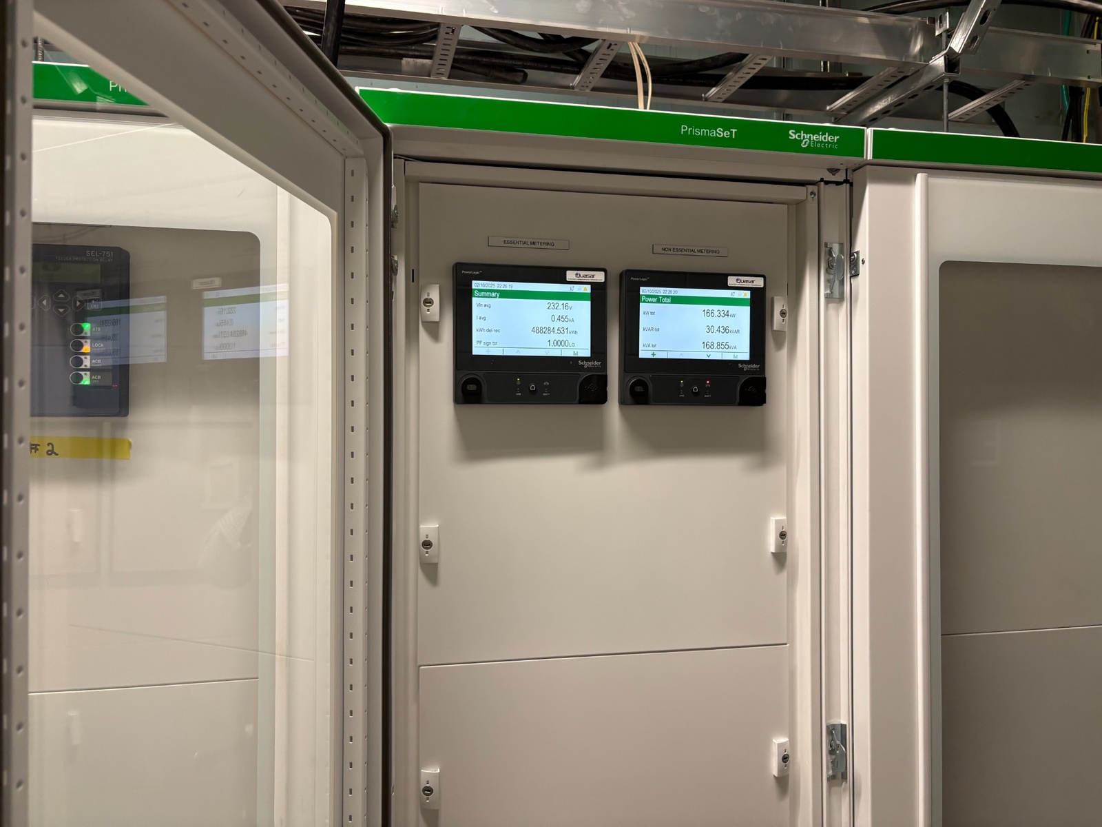 Two Schneider Electric power metering devices mounted inside a white PrismaSeT electrical panel.