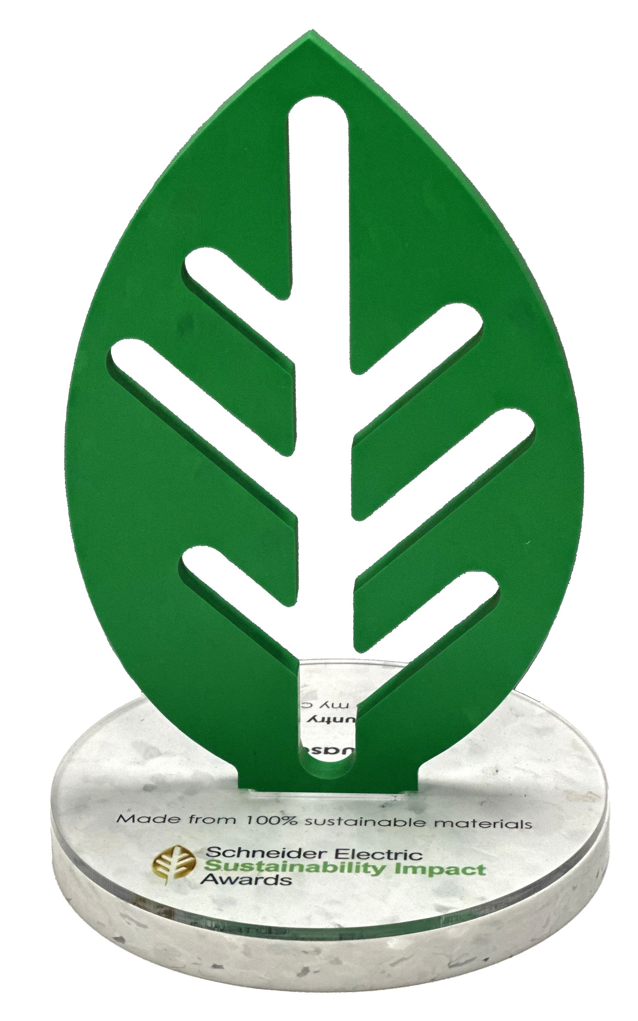 Green leaf-shaped award on a round base with text about 100% sustainable materials and Schneider Electric.