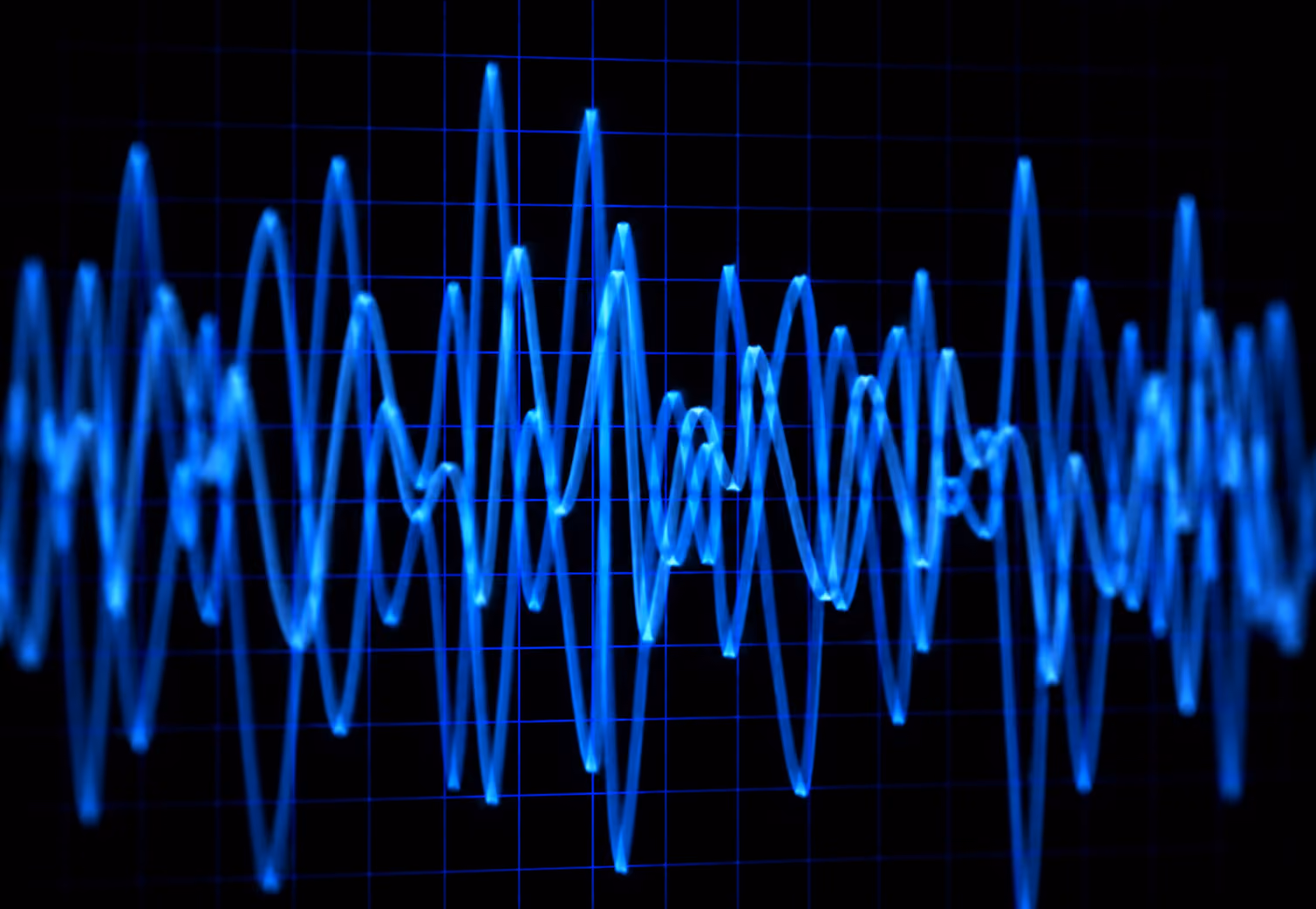 Blue waveform signal over black background with blue grid lines.