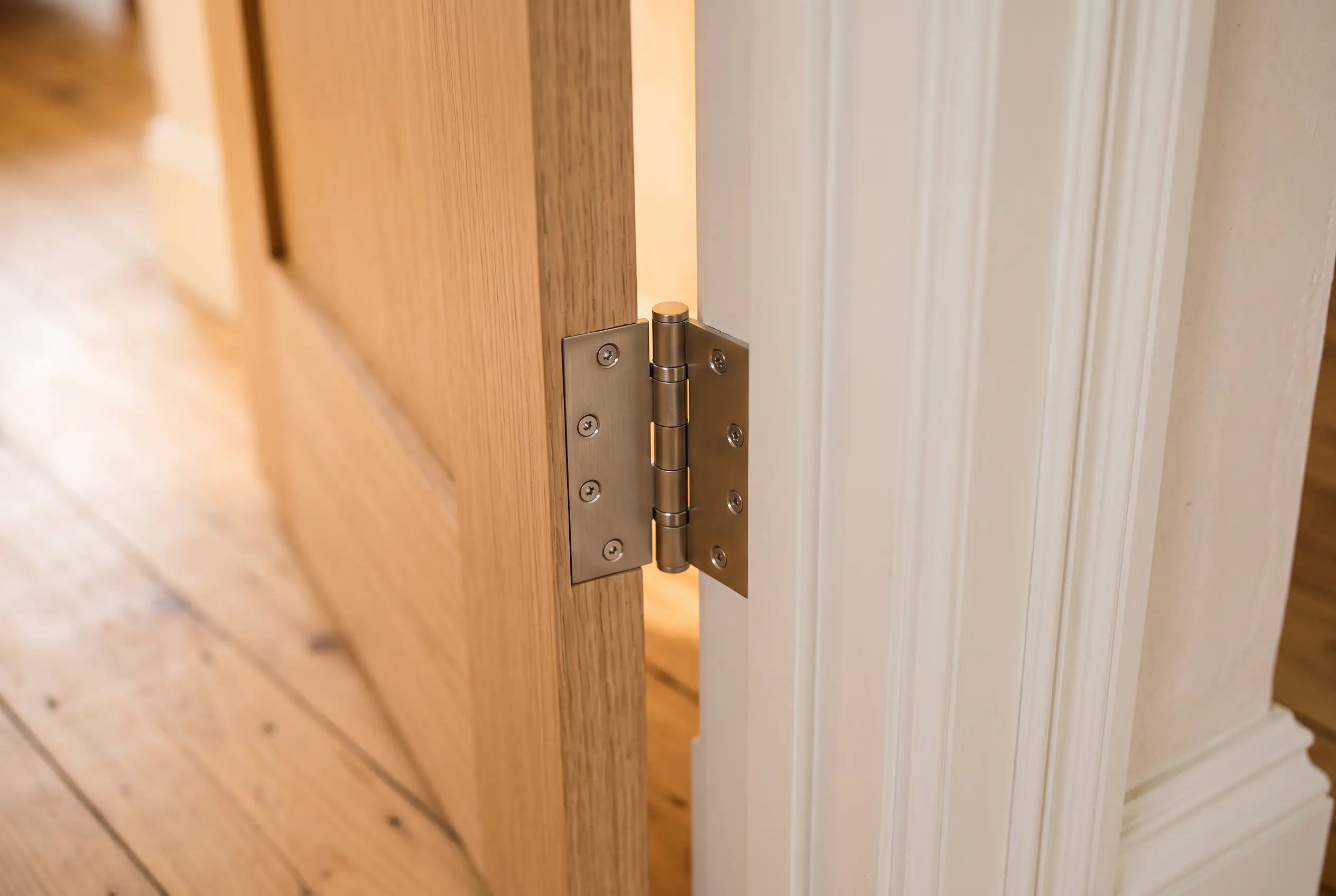 Interior door design concept showing the hinge between an oak door leaf and a painted jamb