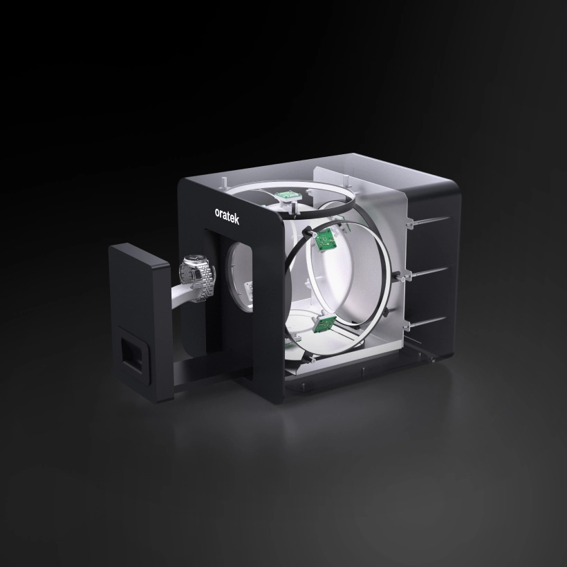 Black Oratek watch winder with a wristwatch mounted inside, showing internal rotary mechanism and circuit boards.