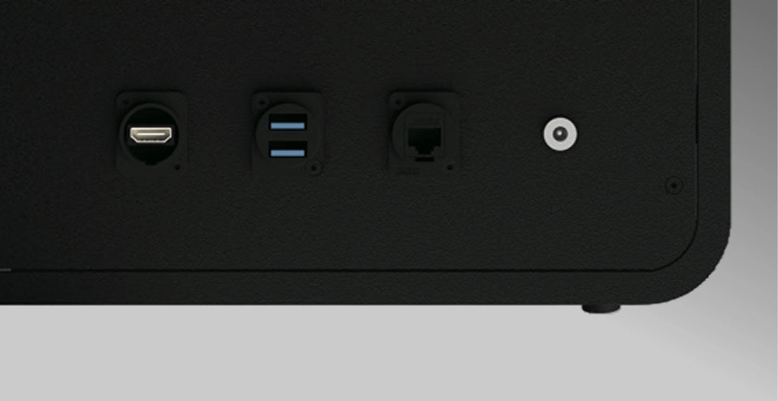 Close-up of a black device panel with HDMI, two USB ports, Ethernet, and a round power connector.