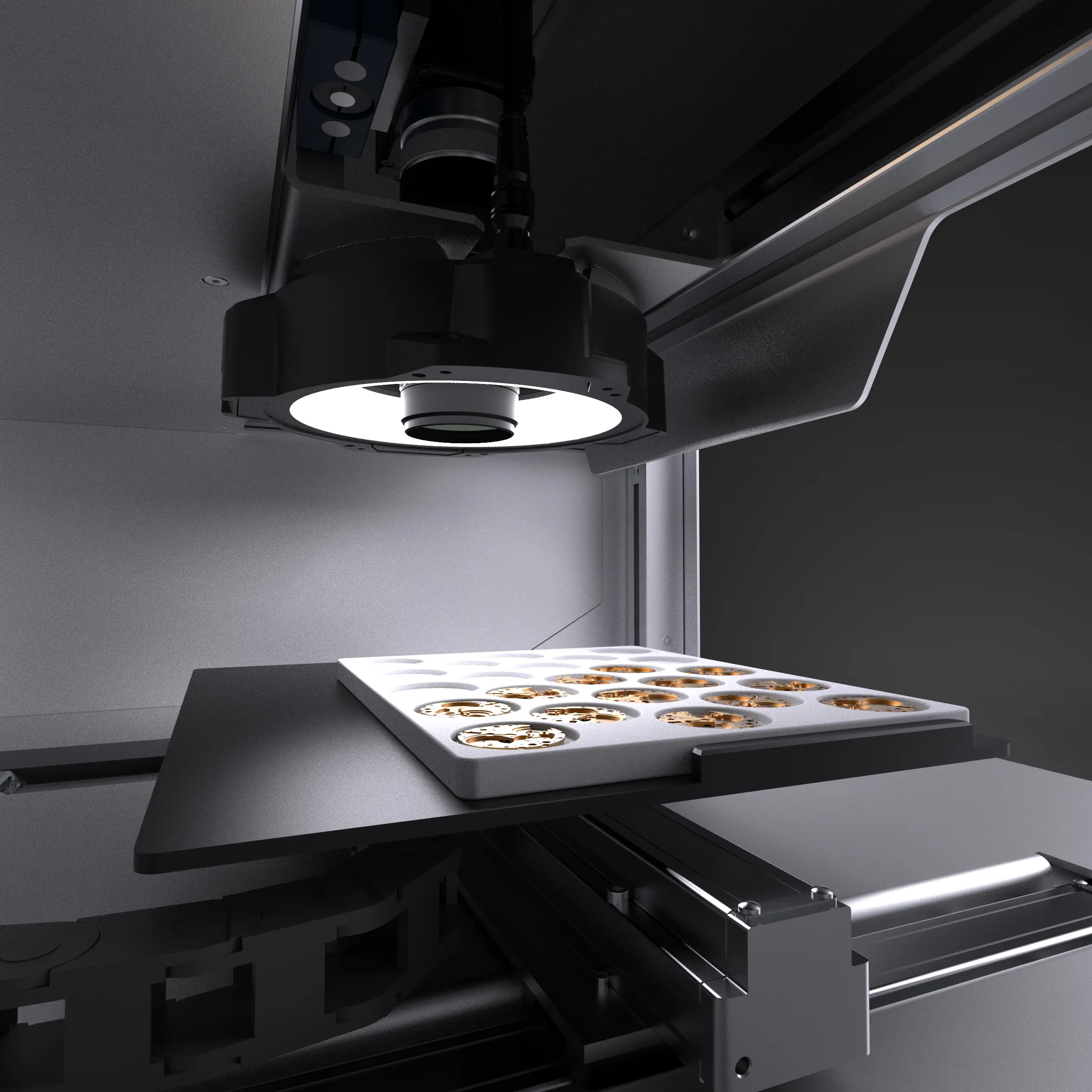 Close-up of a 3D printer with a lit printing head creating small gear-like objects on a flat platform inside a metal enclosure.