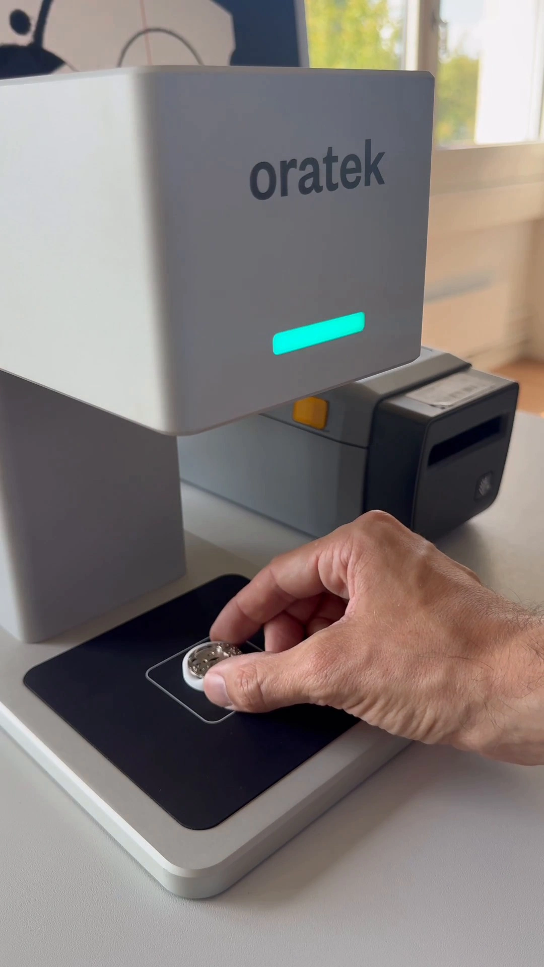 CMS-X serial number check demo video – a watch part placed under the vision head, green LED bar lit, label printer behind