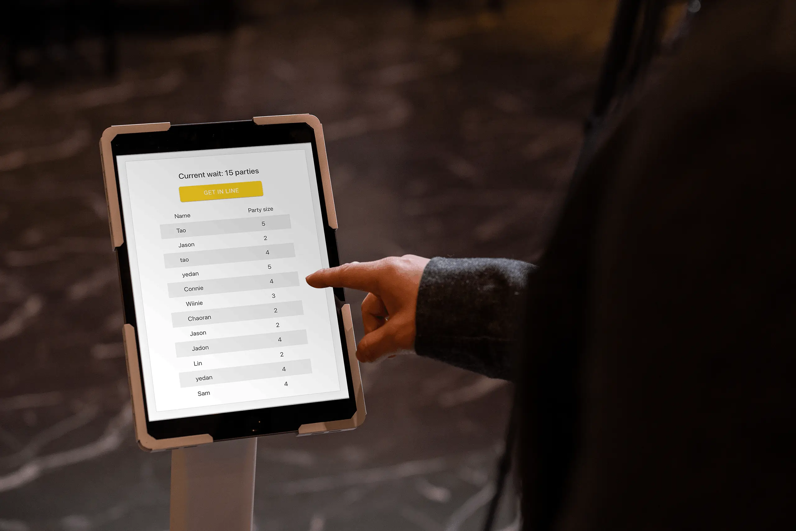Restaurant waitlist interface on a tablet with a “Get in Line” button and a list of parties currently queued for dining.