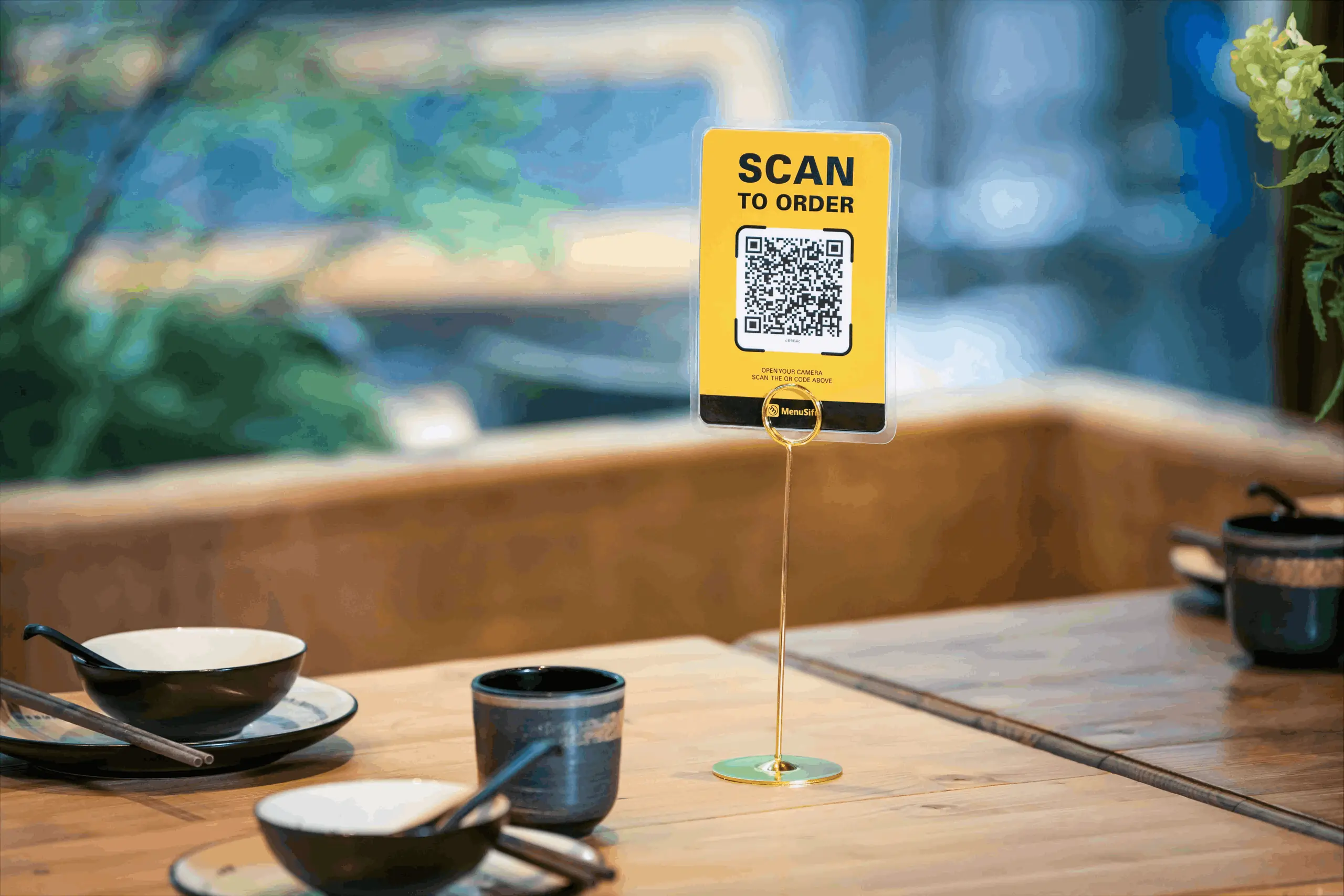 Scan to order restaurant setup with QR code display on a table for contactless menu access and ordering.