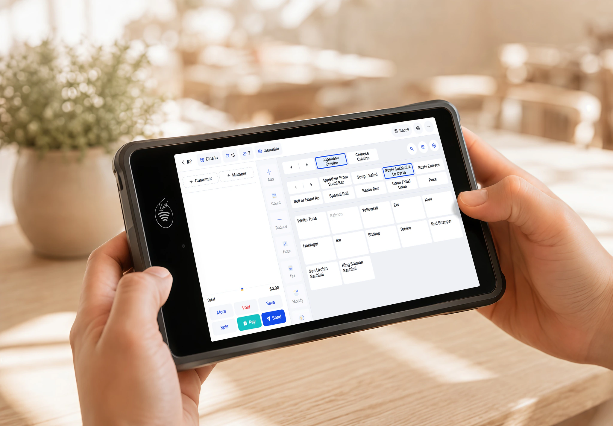 A restaurant staff member updates menu items in real time using a handheld tablet device.