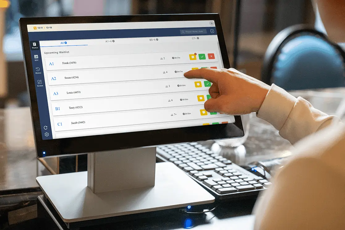 Restaurant staff checks upcoming guest waitlist entries on POS screen, managing table assignments and guest queue efficiently.