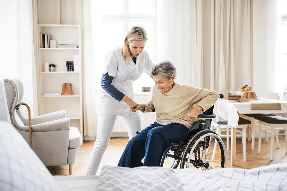 Senior woman being helped by nurse in home care environment.