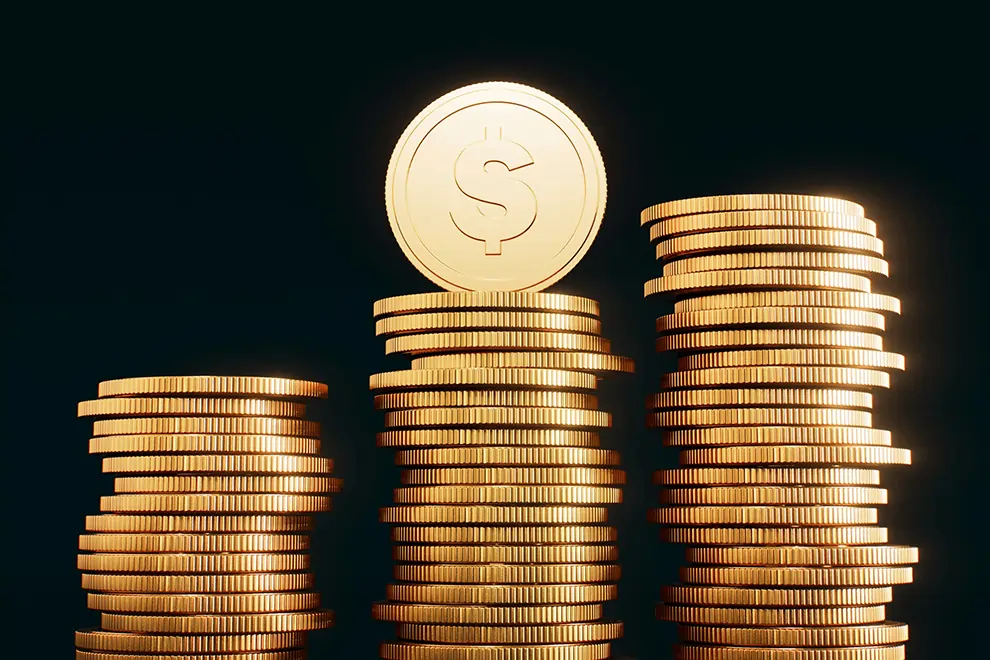 Three stacks of shiny gold coins representing financial growth and business capital funding.