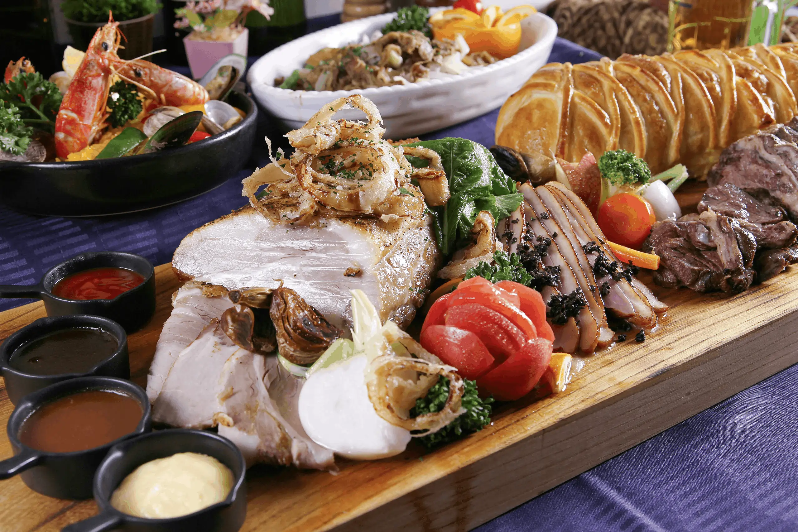 AYCE buffet spread of meats, seafood, and sauces on a platter, ideal for restaurants using a buffet pos system.