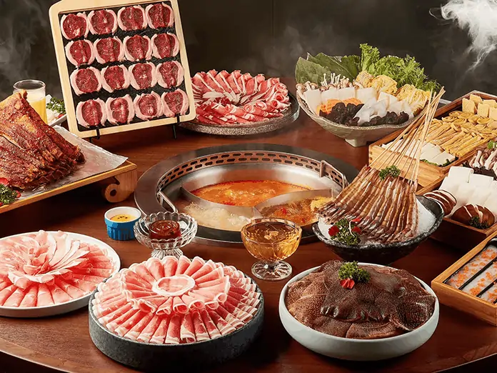 Hot pot feast with sliced meats, skewers, and veggies, ordered using a buffet POS system at Happy Lamb restaurant.