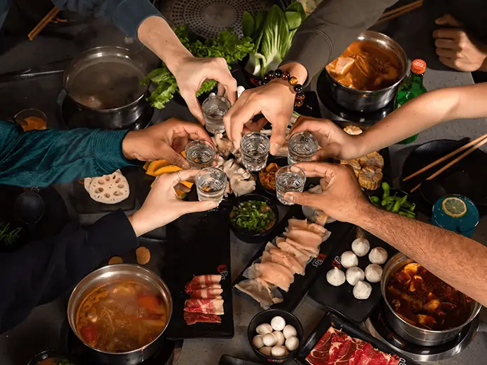 Guests toasting over Korean hot pot at KPOT, with smooth service powered by a reliable korean-restaurant-pos-system.