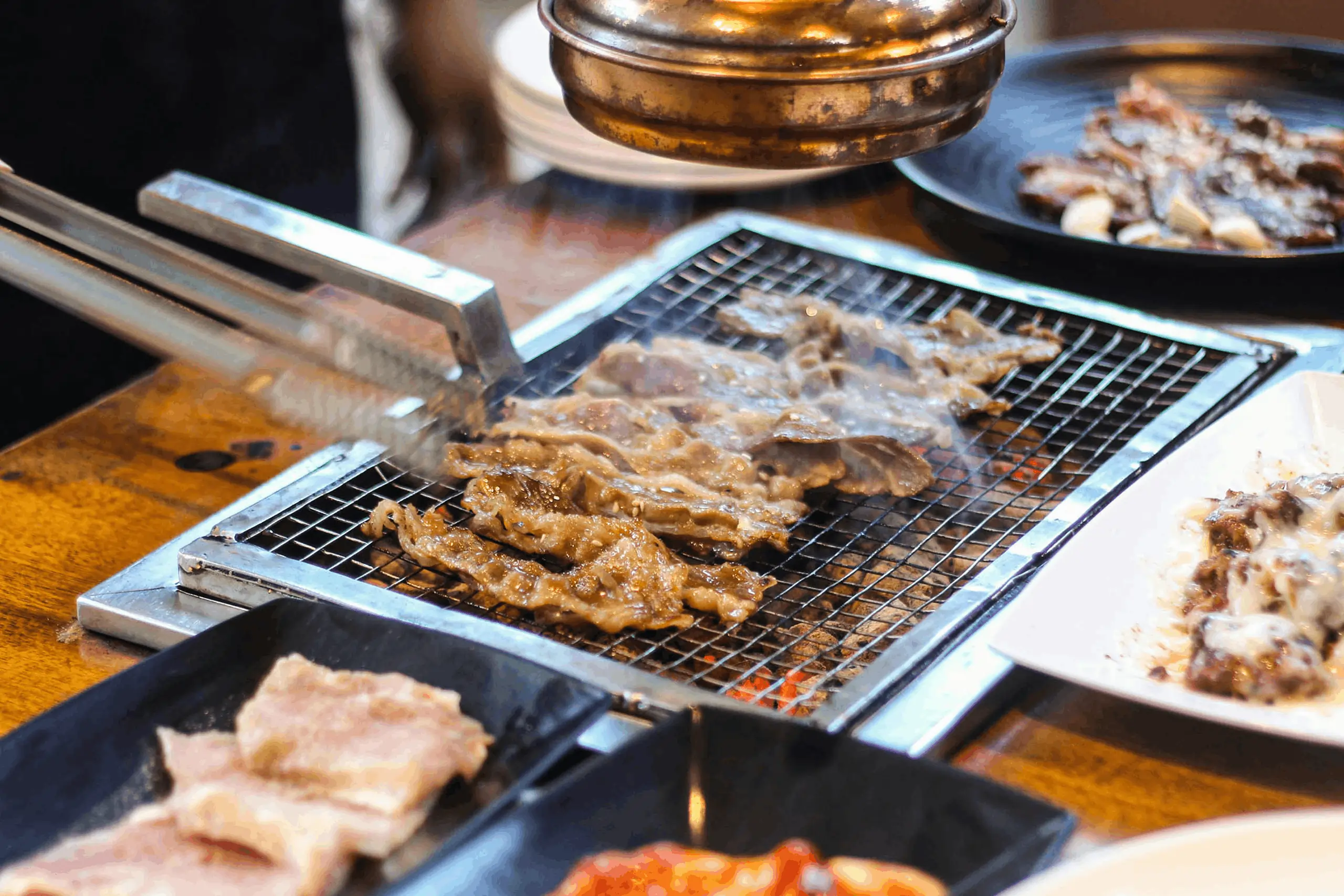Sizzling meat on a Korean BBQ grill, freshly ordered using a modern bbq restaurant pos system.