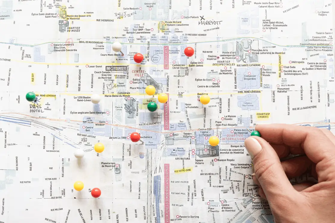 Hand placing pushpin on city map, representing WEFOOD’s local expertise for strategic and efficient restaurant launches.