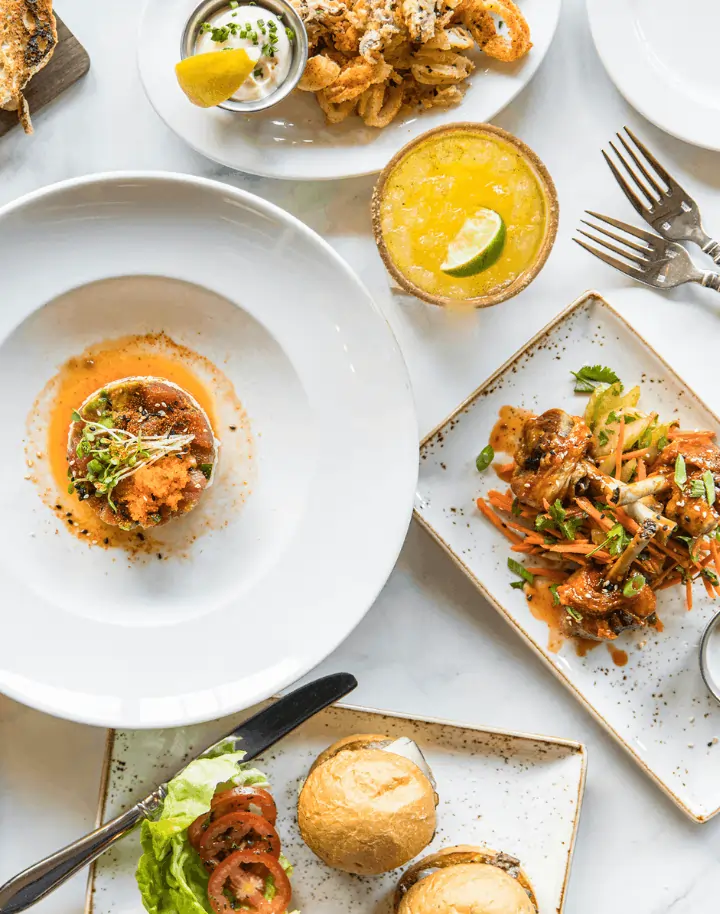 Assorted dishes served after being ordered using a full service restaurant POS system, shown in a stylish flatlay.