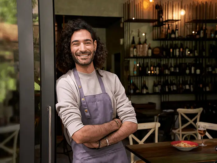 Smiling staff member stands at the entrance, confidently running operations with a Mexican restaurant POS system.