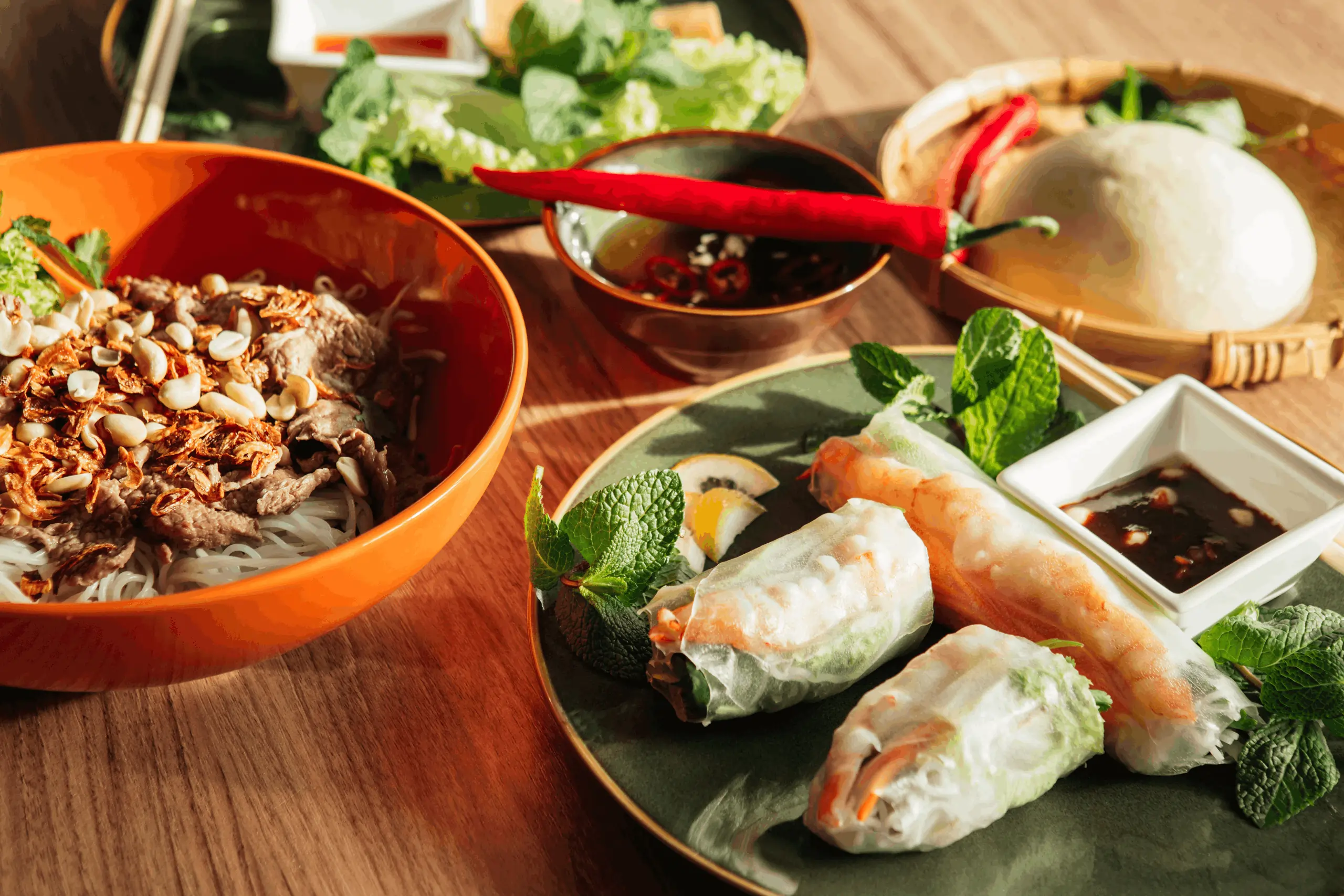 Bowl of beef noodle salad with peanuts and fresh shrimp rolls with herbs, ordered using a modern Vietnamese restaurant POS system.