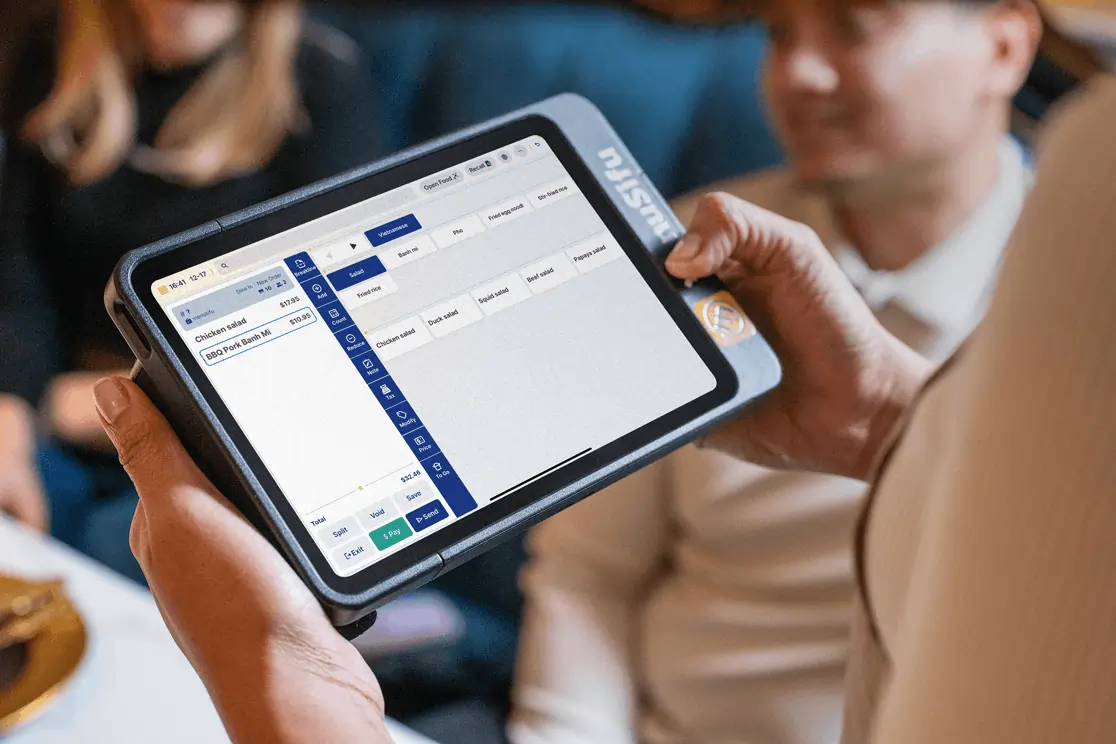 Server uses tablet to take customer order from a Vietnamese menu.