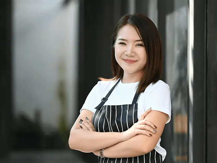 Restaurant owner stands confidently outside, managing operations efficiently using the Menusifu Vietnamese restaurant POS system.