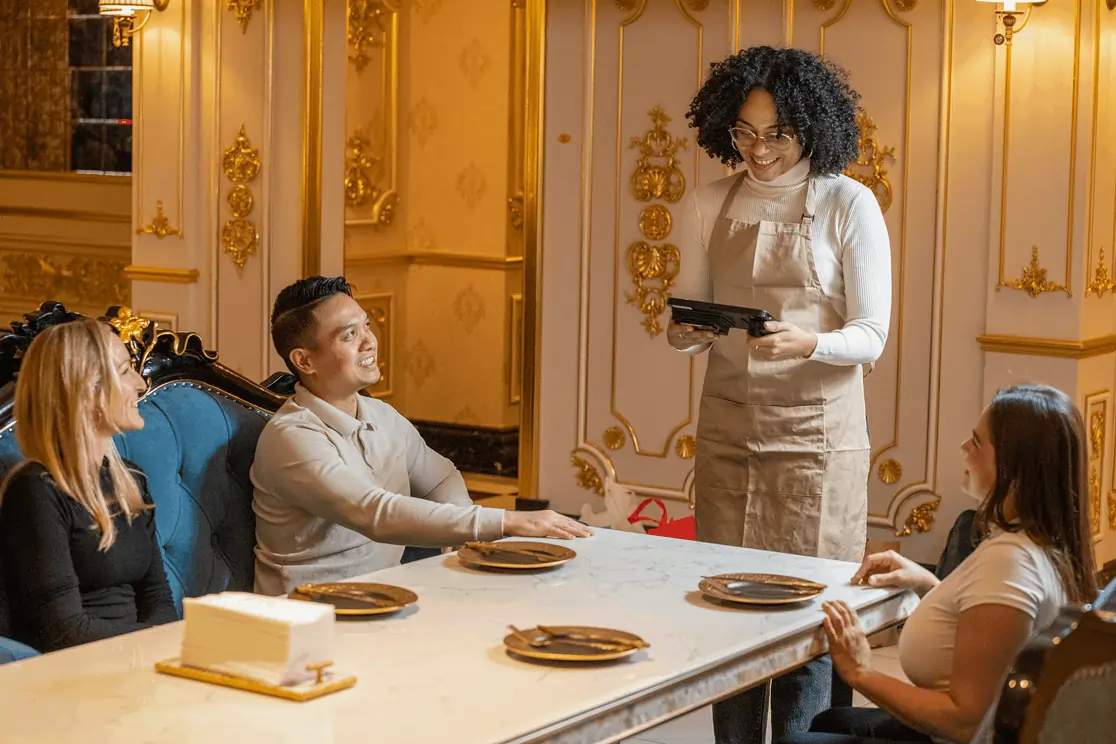 Guests place their order with a server using a tablet, showcasing modern and convenient tableside service.