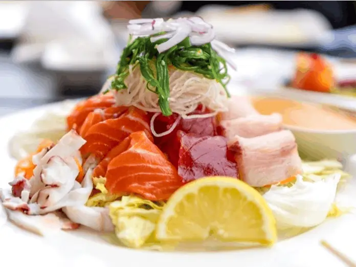 Fresh sashimi plate with radish, lemon, and greens, prepared after order placed using Japanese restaurant POS system.