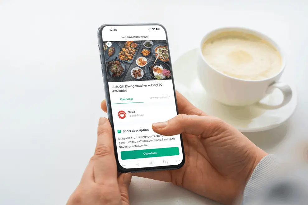 Person holding smartphone with dining deal app screen open, displaying limited-time 50% off voucher and claim now button.