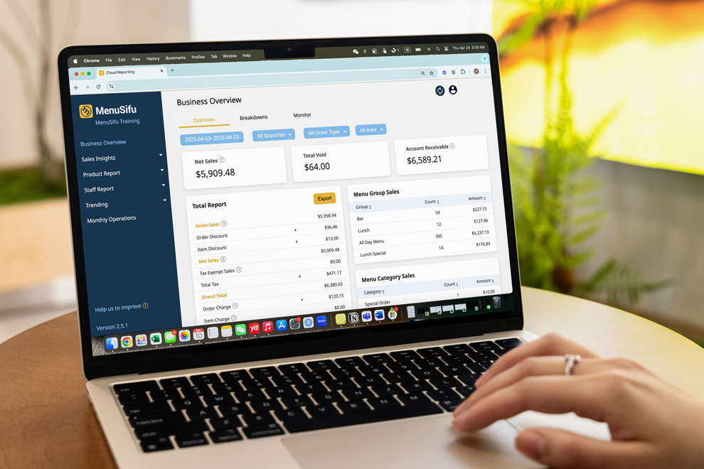 Cloud-based POS sales report dashboard on a laptop with restaurant analytics including totals, breakdowns, and menu group sales.