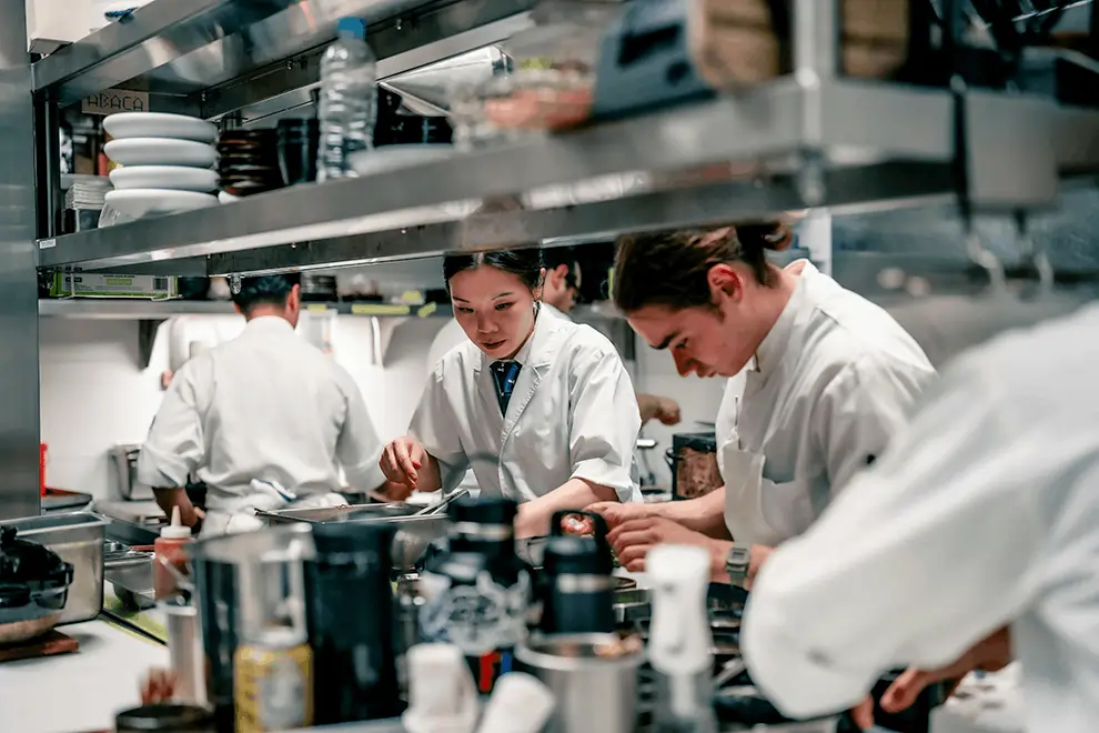 Chefs focus in a busy kitchen, ensuring every dish is prepared accurately and on time without missing a single order.