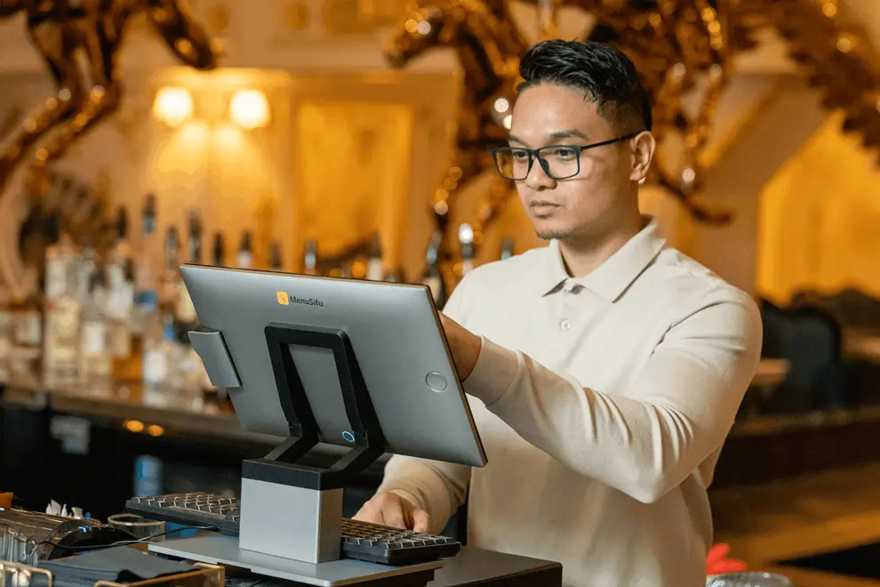 Cashier uses Menusifu POS terminal to enter orders at the bar.