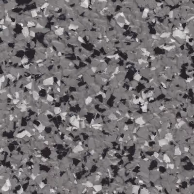 Close-up of a textured epoxy floor coating with black, white, and gray flake chips.