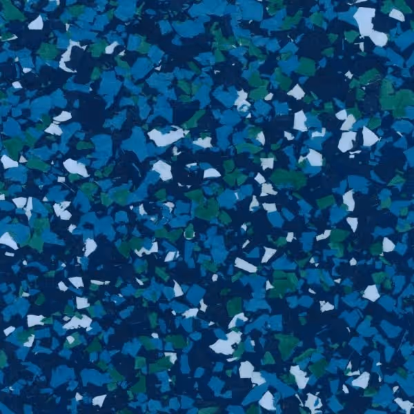 Close-up of a textured epoxy floor coating with blue, green, and white flakes.