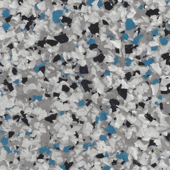 Close-up of epoxy floor coating with white, black, blue, and gray flakes scattered for a textured, decorative finish.
