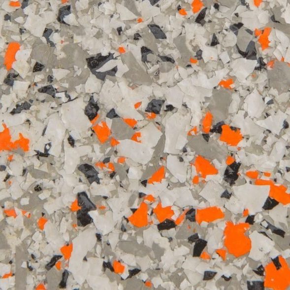 Close-up of a textured surface with scattered flakes in white, gray, black, and bright orange colors.