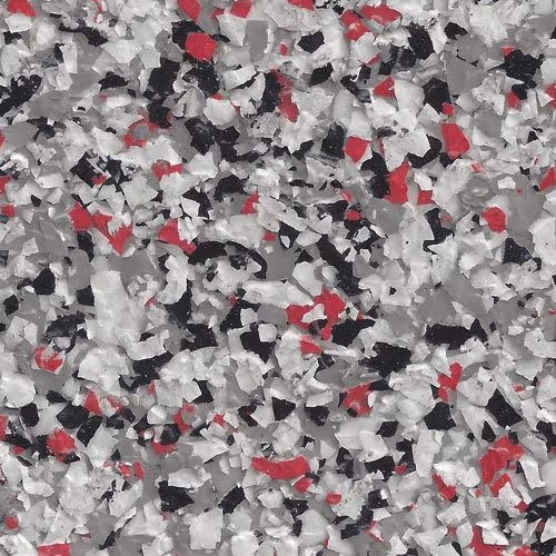 Close-up of epoxy flake flooring with scattered chips in white, black, gray, and red colors.