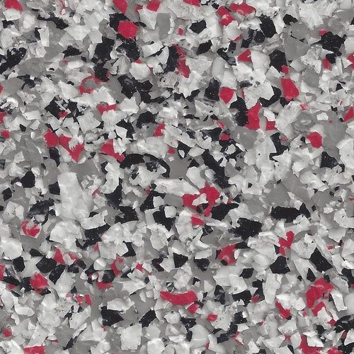Close-up of epoxy flake flooring with scattered chips in white, black, gray, and red colors.