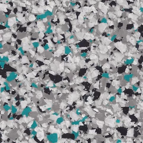 Close-up of epoxy floor coating with a flake pattern in white, teal, black, and gray colors.