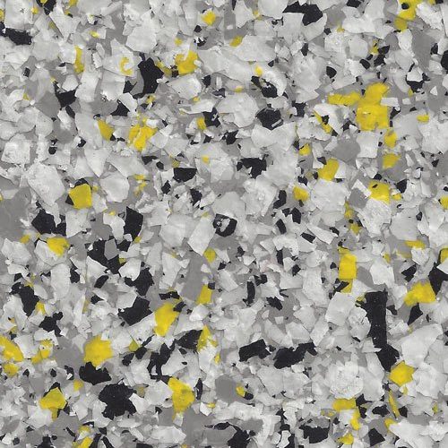 Close-up of a textured surface with white, black, grey, and yellow epoxy flakes creating a speckled pattern.