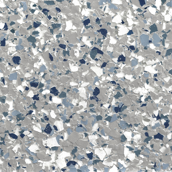 Close-up of epoxy flake flooring with a non-uniform pattern of gray, white, and blue flakes.