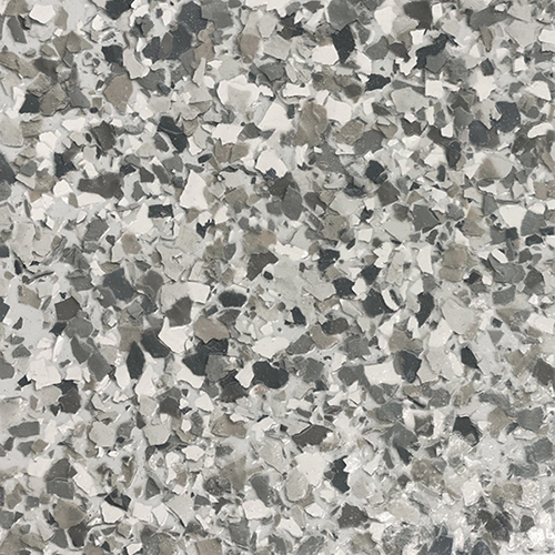 Close-up of epoxy floor with mixed gray, black, white, and beige flake pattern.