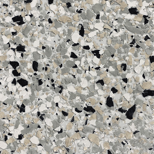 Close-up of epoxy floor coating with a mix of black, gray, white, and beige flakes scattered on a light gray base.