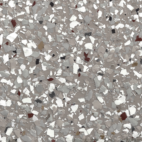 Close-up of epoxy flake flooring with gray base and scattered white, black, and brown flakes.