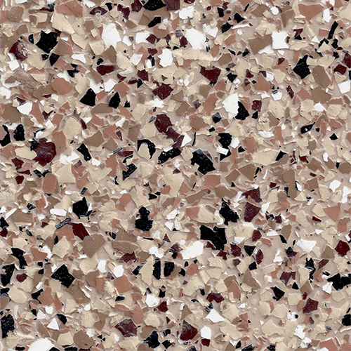 Close-up of epoxy floor with red, black, beige, and white flakes creating a textured speckled pattern.