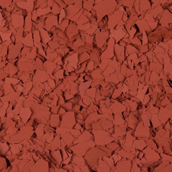 Close-up of scattered terracotta-colored flakes with irregular shapes and rough edges.