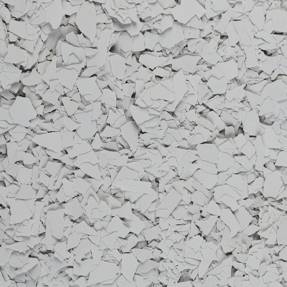 Close-up of light grey, irregularly shaped paint flakes scattered densely.