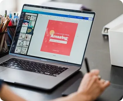 Close-up of a person typing code on a laptop keyboard with CSS code visible on the screen.