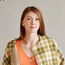 Woman in yellow and white plaid button up shirt standing beside kitchen counter