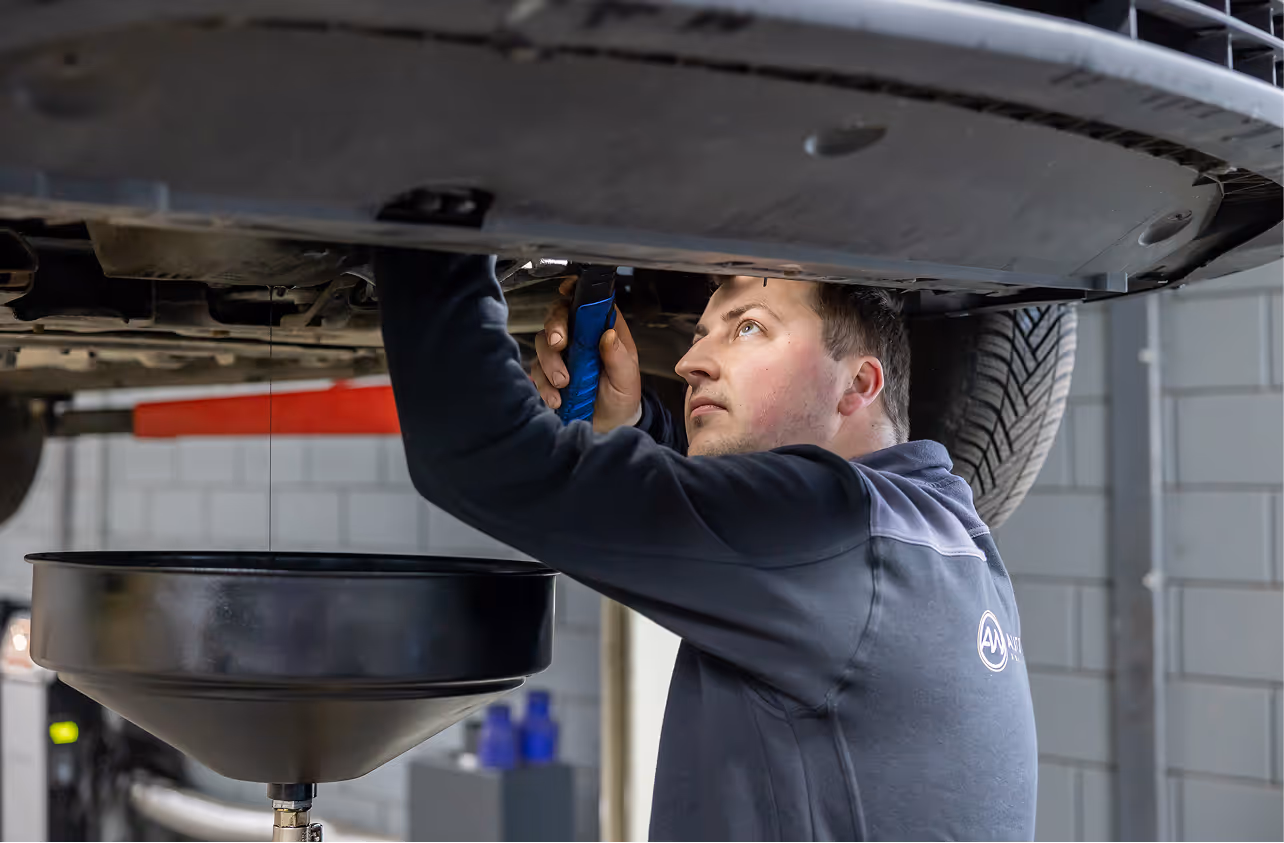 Een monteur inspecteert een distributieriem van een personenwagen